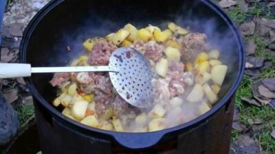 Картофель с тушенкой в кастрюле на костре