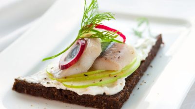 Бутерброды с маслом и сельдью на черном хлебе