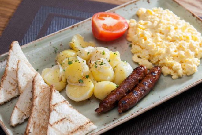 Американский завтрак из сосисок, картофеля и омлета
